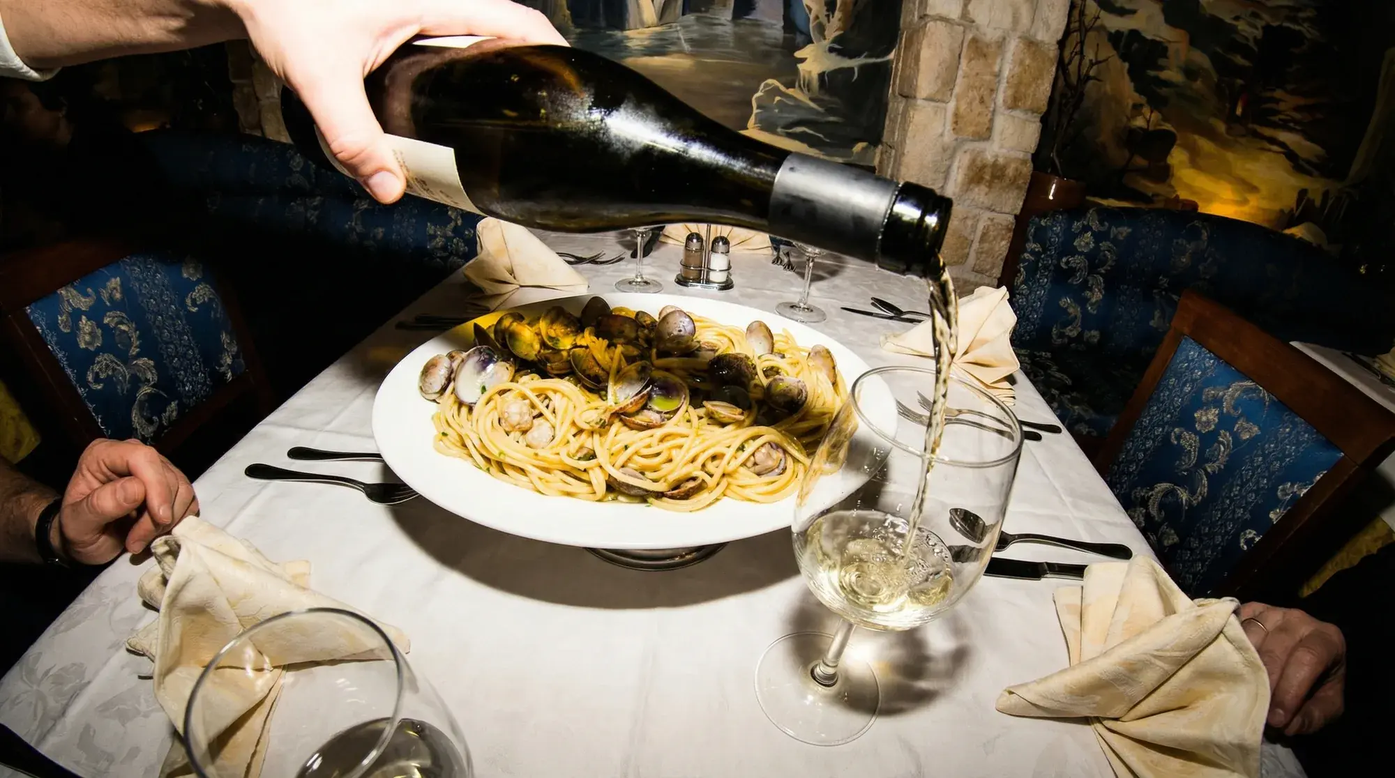 Pasta Vongole und Wein am Tisch bei La Commedia.